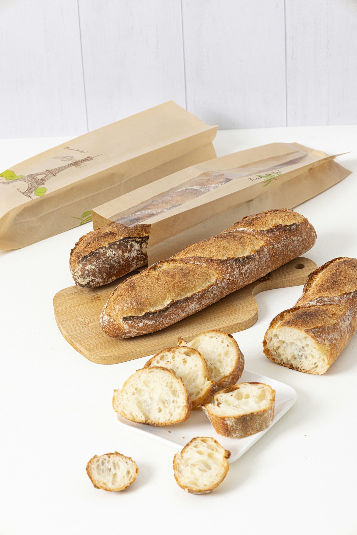 Baguettes in unbranded printed paper bakery bags