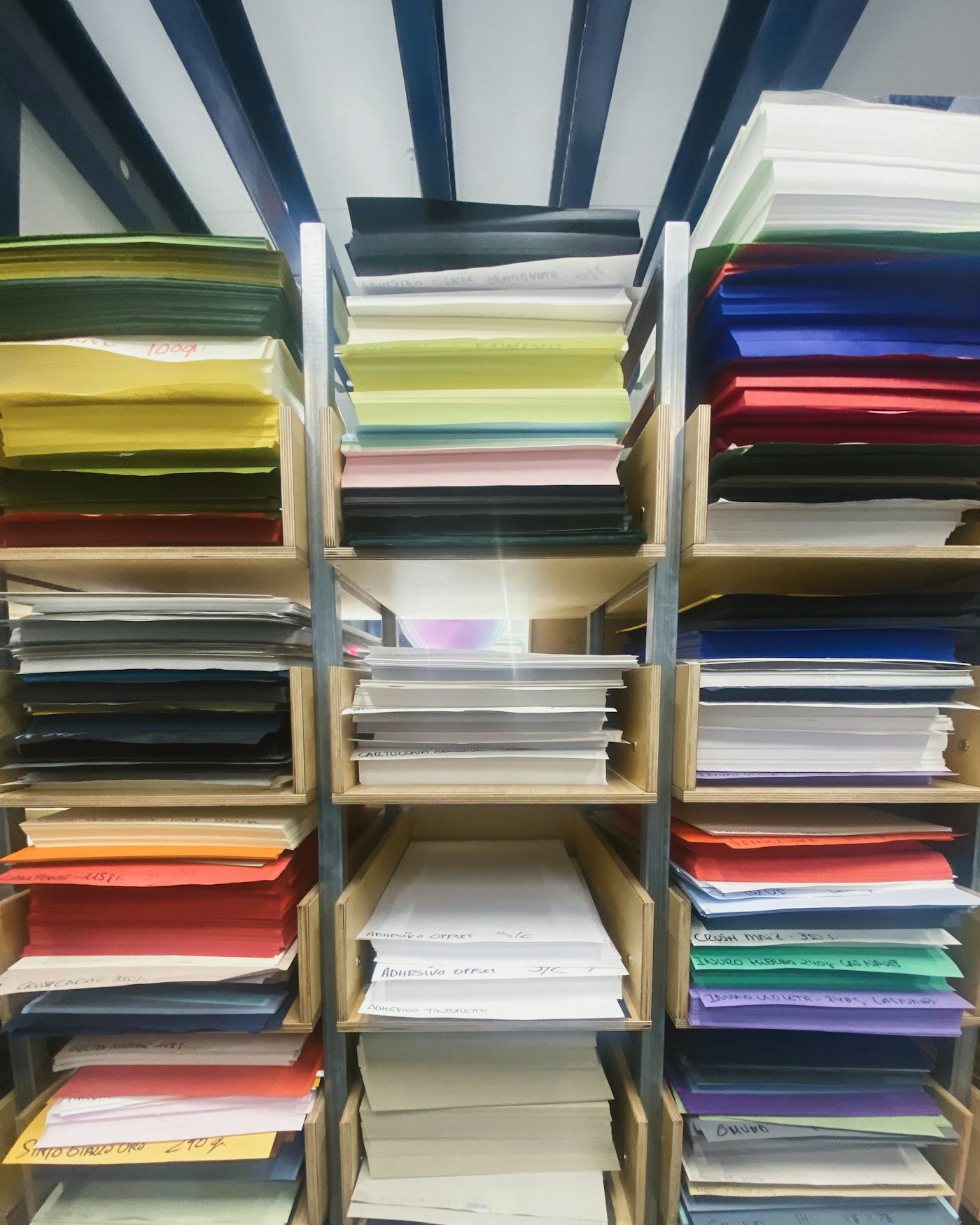 Shelves stacked with paper stock in many colours